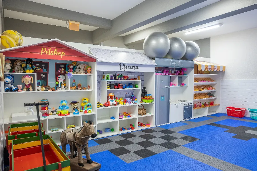 Sala lúdica do Colégio Atlântico com mini lojinhas de Petshop, Oficina e Mercado, ambiente interativo que estimula o faz de conta e a aprendizagem criativa.