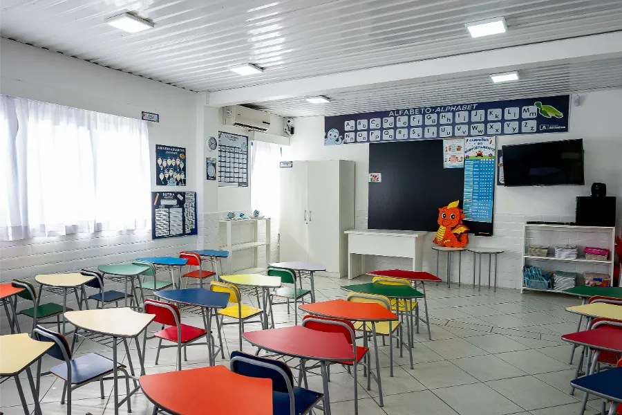 Sala do Ensino Fundamental do Colégio Atlântico com carteiras coloridas e decoração educativa, projetada para aulas dinâmicas e aprendizado criativo.