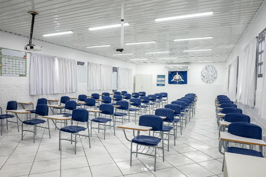 Sala do Ensino Médio do Colégio Atlântico com carteiras azuis organizadas, ambiente amplo e climatizado voltado à concentração e preparação para o vestibular.