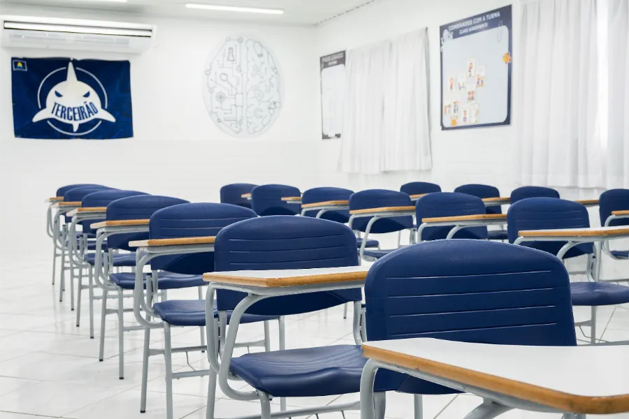 Detalhe da sala do terceirão do Colégio Atlântico com bandeira da turma e carteiras azuis, espaço de estudo e convivência dos alunos concluintes.